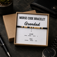 A Morse code bracelet for grandad presented in a light brown gift box with a white insert card. The bracelet features black and natural wood beads.