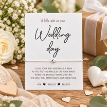 Wedding day wish string bracelet. A square white card with wedding-themed text and a delicate bracelet wrapped around the centre. White cotton cord bracelet with a silver star charm. Wedding day gift.