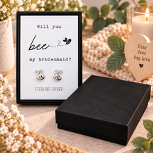 A pair of silver bee stud earrings displayed in a black presentation box with a printed card that reads 'Will you bee my bridesmaid?'.