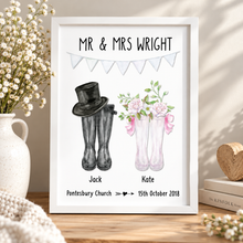 A personalised wedding print on a wooden table, featuring the text 'MR & MRS WRIGHT' with illustrations of black rain boots and pink rain boots with flowers. Personalised wedding wellie print 